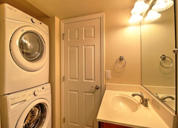A white washing machine and dryer in a small bathroom.