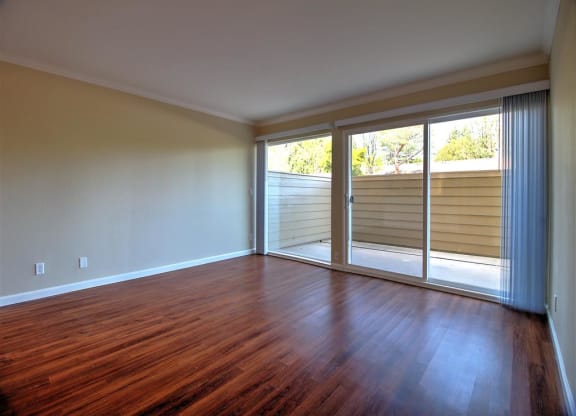 A room with wooden floors and sliding glass doors.