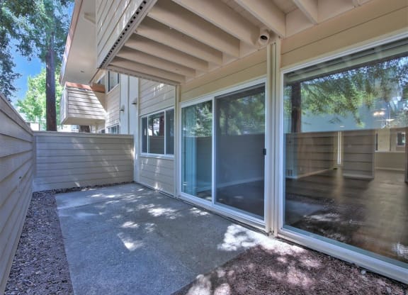 A sunny day at a house with a glass door and a grey carpet.