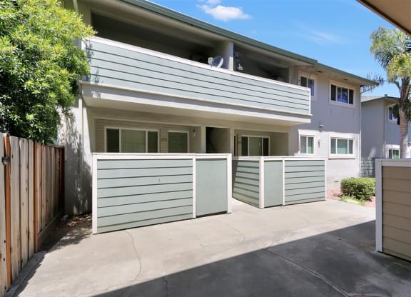 A sunny day at a two-story residential building with garages.