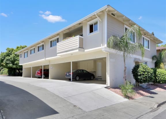 A two-story house with a garage and a car parked inside.