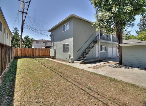 a gray house with a yard and a fence