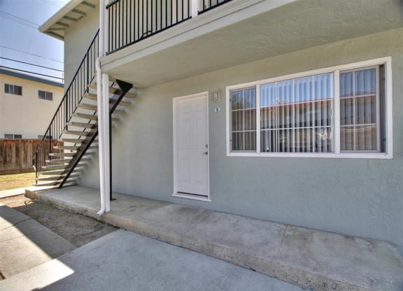 the front door of an apartment building with a staircase