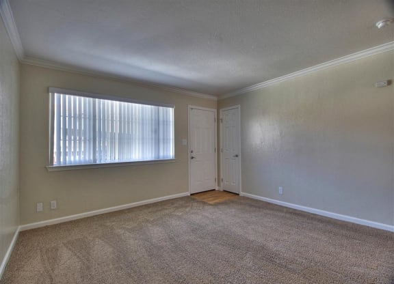 an empty living room with a window and a door
