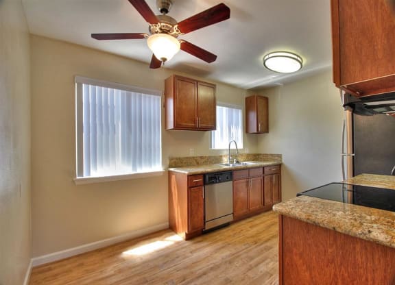 a kitchen with wooden cabinets and a ceiling fan