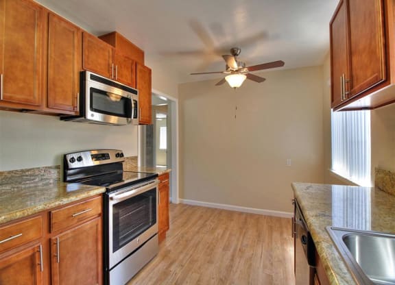 a kitchen with a stove and a ceiling fan