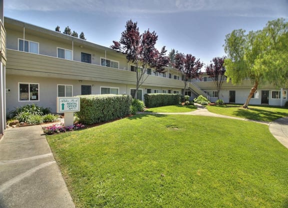 A well-maintained lawn in front of a building with a sign that says
