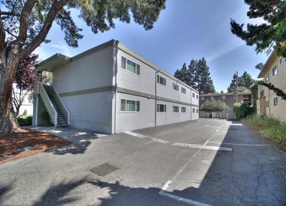 A concrete building with a parking lot in front.