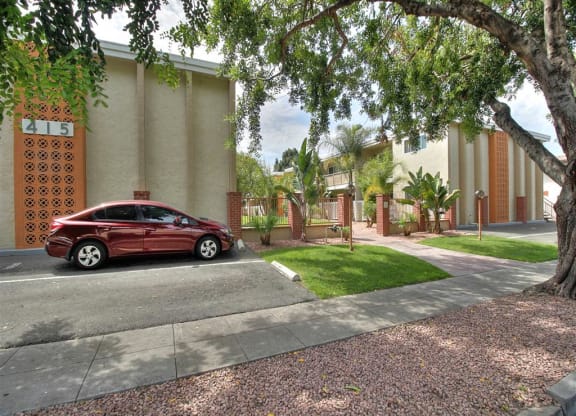 A red car is parked on the side of a street.