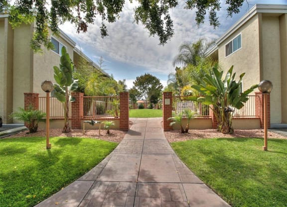 A pathway leads to a gate in a landscaped yard.