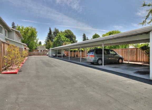A car is parked under a covered driveway.
