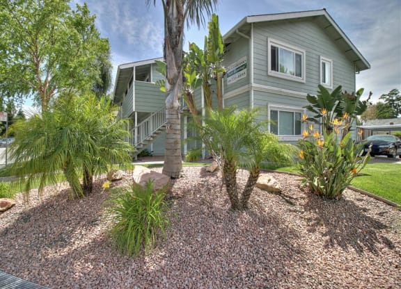 A building with a grey exterior and a garden in front.