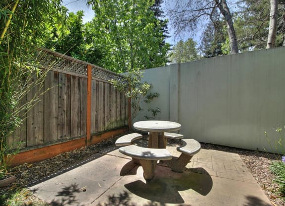A backyard with a table and chairs.