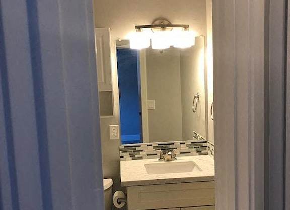 A bathroom with a sink and mirror.