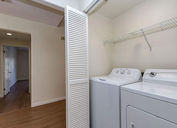 A white washing machine and dryer in a small laundry room.