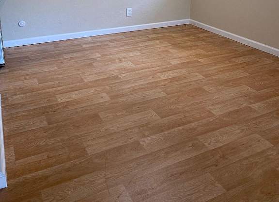 a living room with a wood floor and a ceiling fan