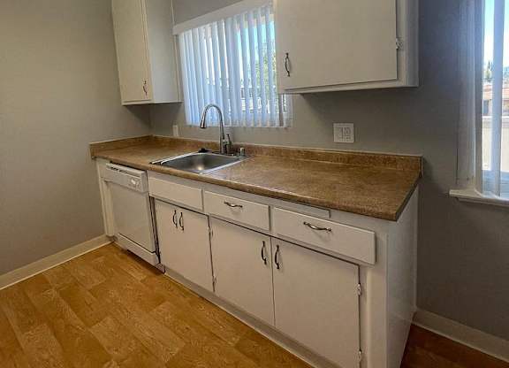 a kitchen with white cabinets and a sink