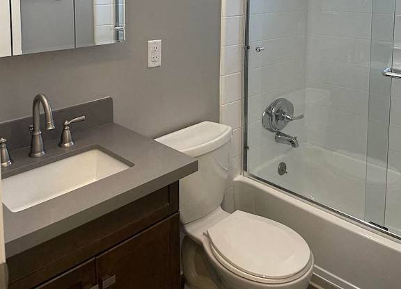 A white toilet sits next to a sink in a bathroom.