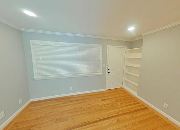A room with wooden floors and a white door.