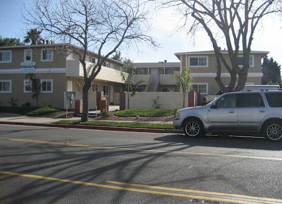 A silver car is parked on the right side of the street.