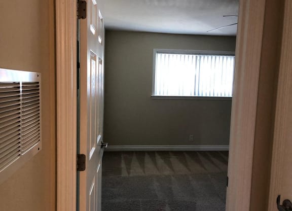 an empty room with a window and a door