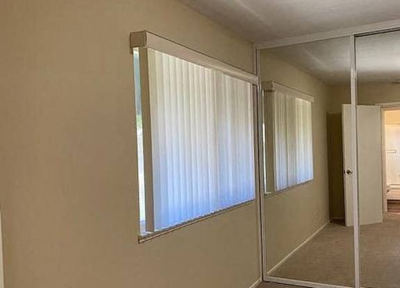 an empty room with a window and a mirror