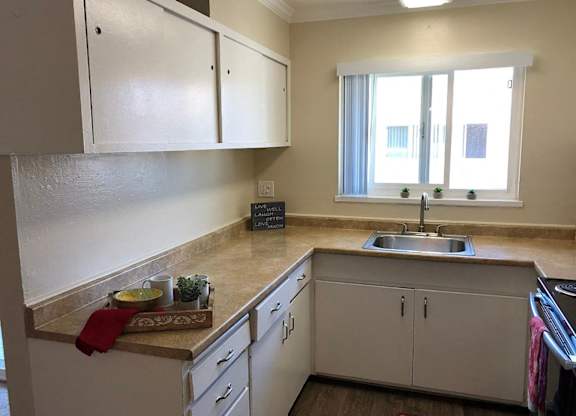 A kitchen with white cabinets and a sink.
