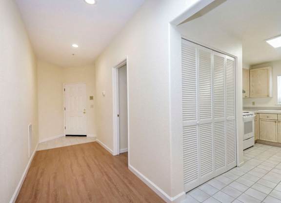 A kitchen with white cabinets and a white door.
