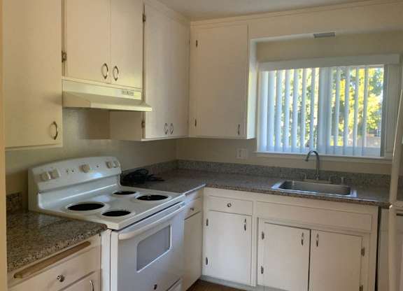 A white kitchen with a stove and cabinets.