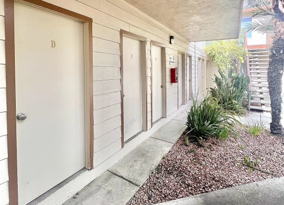 the entrance to a building with several doors and a sidewalk