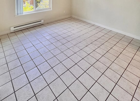 an empty living room with a ceiling fan and tiled floor