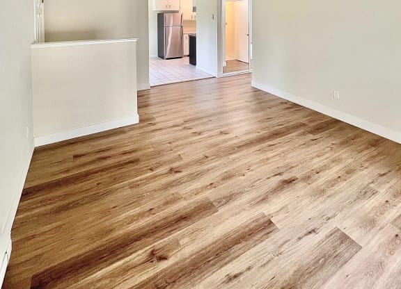 an empty living room with a hard wood floor