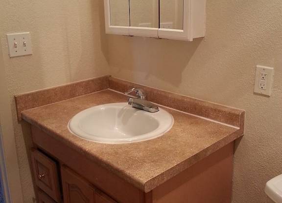 A bathroom with a sink and a mirror above it.