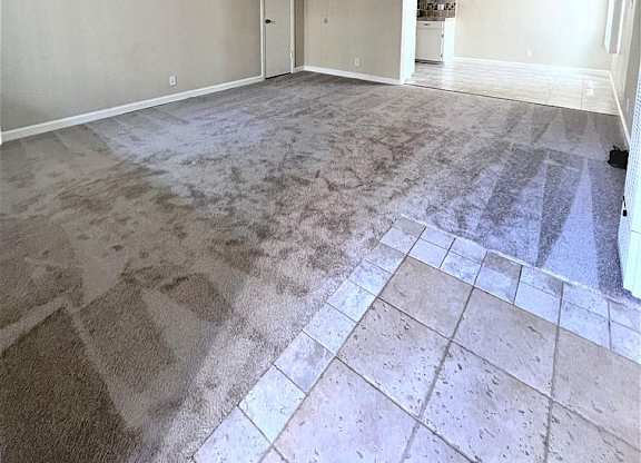 A room with a carpeted floor and a doorway leading to another room.