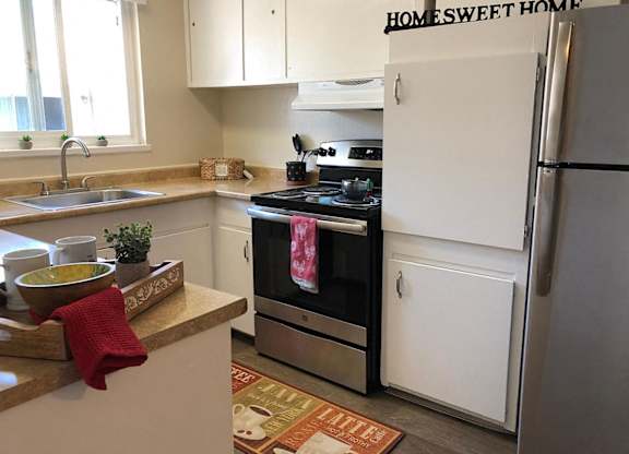 A kitchen with a white refrigerator and a black stove top oven.