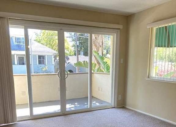 an empty living room with glass doors to a patio