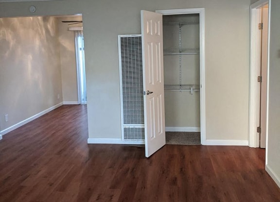 an empty living room with a door to a closet