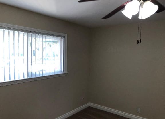 a living room with a window and a ceiling fan