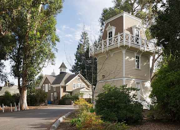 a house with a tower on the side of a street