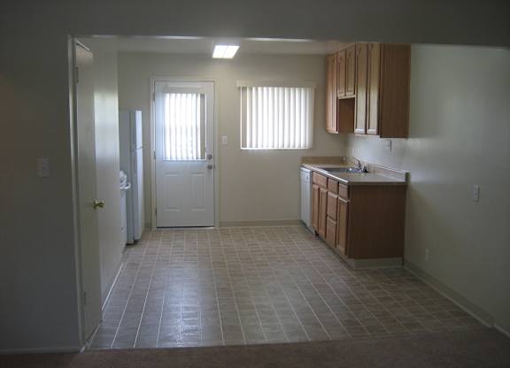 A kitchen with brown cabinets and a white door.
