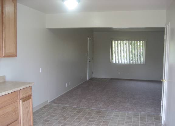 A room with a tile floor and a window with blinds.