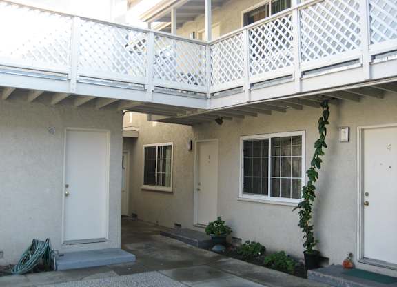 A white house with a balcony and a door.