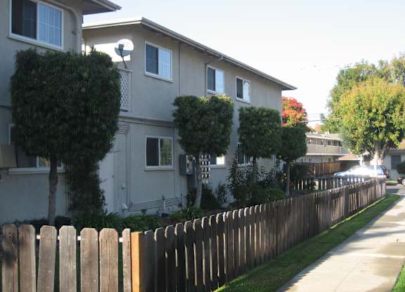 A row of houses with a wooden fence in front.