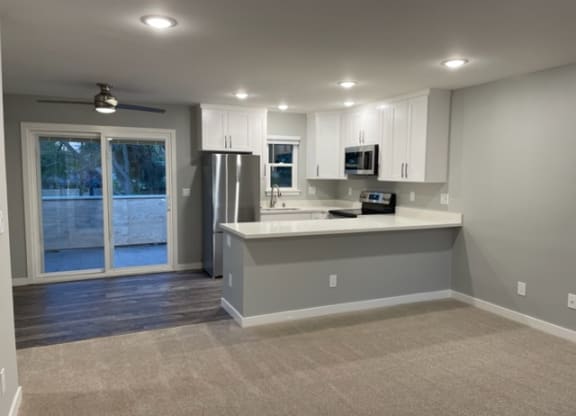 A kitchen with white cabinets and a grey island.