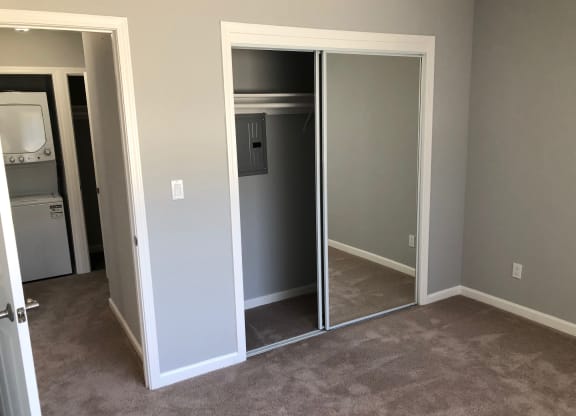 a living room with a closet and a door to a laundry room