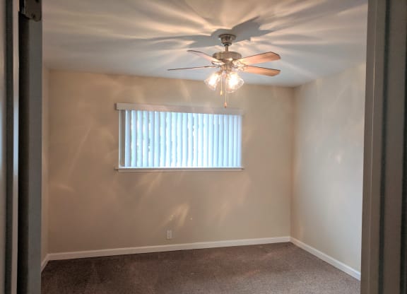 a bedroom with a ceiling fan and a window