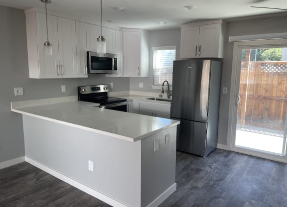 A kitchen with a white island and stainless steel appliances.