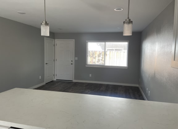 A room with a white table and two hanging lights.