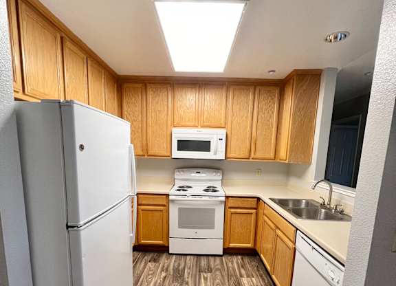 A kitchen with wooden cabinets and a white refrigerator.