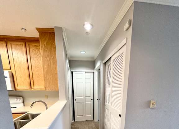 A long hallway with a white door at the end.